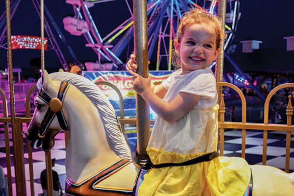 Showing a little girl on a carousel.